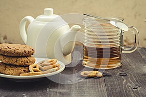 White teapot, cookies and half glass tea/white teapot, cookies a
