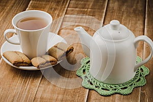 white teapot and cup of tea with cookies/white teapot and cup of