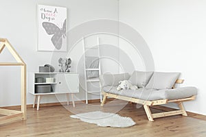 White teddy bear on grey sofa