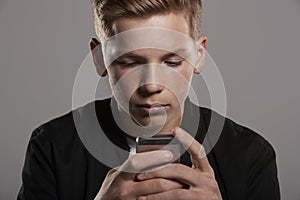 White teenage boy using mobile phone, head and shoulders