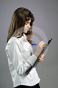 White teenager writing on paper with pen