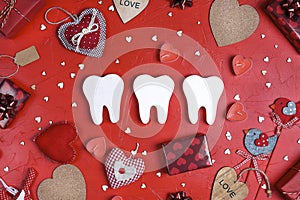 White teeth surrounded by gifts and hearts on red background. Dental Valentine card