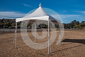 White tent in brown grass field under blue sky