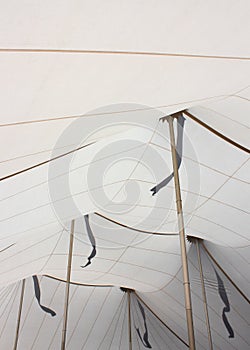 White Tent Ceiling Interior With Gold Poles and Flag Shadows