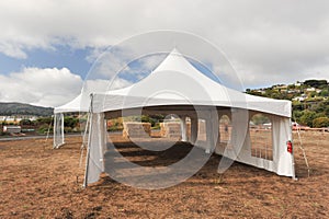 White tents in a dry field outdoors