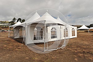 White tents in a dry field outdoors