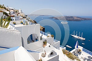 White terraces of Santorini and ships on the blue ocean.