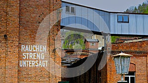 White text of " Rauchen Streng Untersagt" on the exterior brick wall of an abandoned building photo