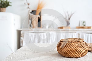 The white textured kitchen is blurred in the background in the style of shabby. A large table in an ecological style and loft