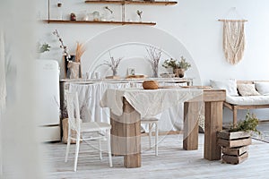 White textured kitchen in the style of shabby. A large table in an ecological style and loft style. Rustic shelves, napkins, old r
