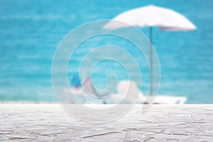 white textured surface on blur beach umbrella on the sea background