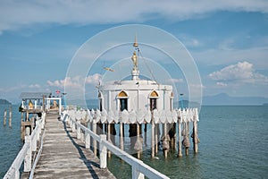 White Thai Buddist temple with pier in sea (Bot Klang Thale)