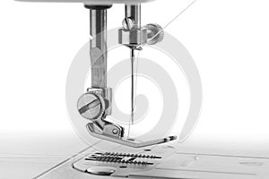 White thread through the needle eye.The side of the sewing machine