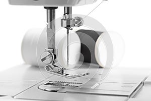 White thread through the needle eye.The side of the sewing machine