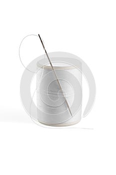 White thread through the needle eye with spool.