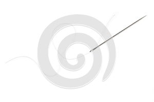 A white thread passed through the eye of a needle rests on a white background.