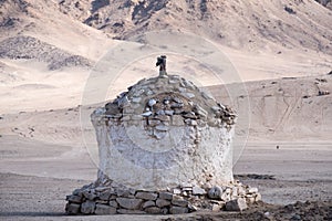 A white Tibetan stone stupa with mountain view