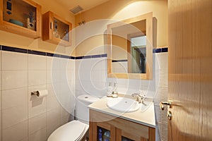 White tile and orange paint bathroom with white porcelain sink,