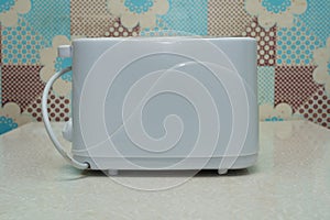 White toaster on a kitchen counter with a patterned background