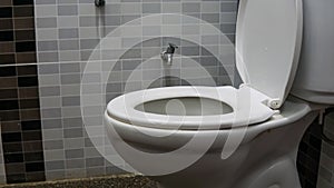 White toilet bowl seat in a modern interior design bathroom with pebble wash floor