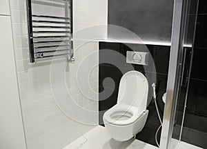 White toilet bowl with thermostatic electric towel rail for bath photo