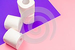 White toilet paper rolls on bright color block background