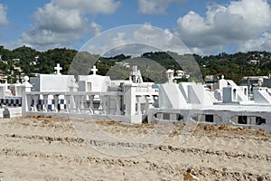 White tombstones and graves in a cemetery near the beach in Castries, Saint Lucia.