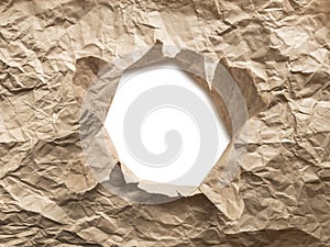 White torn hole in brown crumpled craft paper with clipping path. Eco waste recycling concept