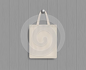 White tote on wood wall. Mockup of eco canvas bag with handle. Cotton fabric tote. Reusable cloth of ecobag for shopping, grocery
