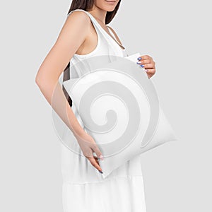 White totebag mockup on a girl in a sundress, close-up, isolated on background