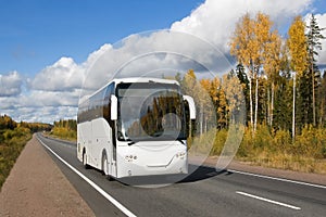 white tourist bus on autumn country highway