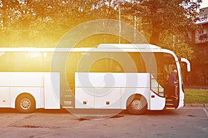 White tourist bus for excursions. The bus is parked in a parking lot near the park photo