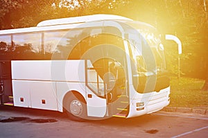 White tourist bus for excursions. The bus is parked in a parking lot near the park photo