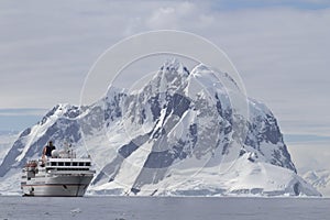 White tourist ship a summer day on a background of mountains of