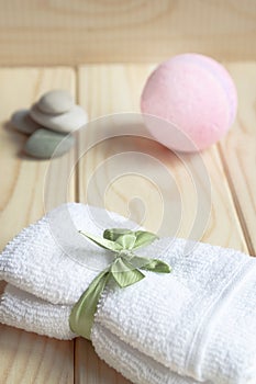 White towel, bath salt on a wooden background. The concept of cosmetology services, body care, natural cosmetics, spa treatments.