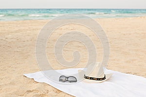 White towel on the beach with sunglasses and hat photo