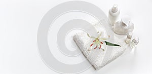 White towel with lily and body care bottles