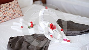 White towel swan with flowers on bed in hotel