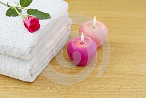 White towels with pink lit candles