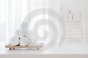 White towels on wooden pedestal over blurred spa room background