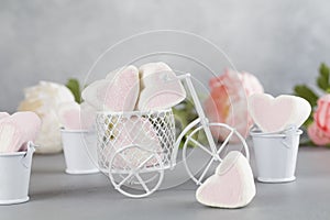 White toy bike carrying candy in form of hearts. Valentines day minimalism background