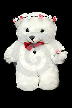 White toy teddy bear present for a child. Black background