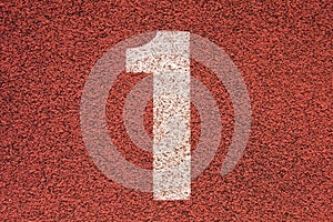 White track number on red rubber racetrack, texture of running racetracks in small outdoor stadium