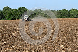 White Tractor Tilling Field