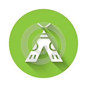 White Traditional indian teepee or wigwam icon isolated with long shadow. Indian tent. Green circle button. Vector