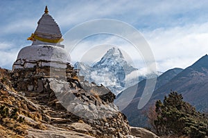 White traditional Tibetan stupa in front of Ama Dablam mountain peak in Everest base camp trekking route, Himalaya mountains range