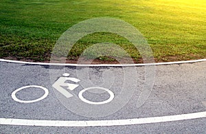 White traffic sign, bicycle lane symbol on curve asphalt road wi