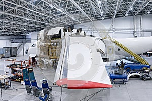 White transport airplane in the aviation hangar. Aircraft under maintenance