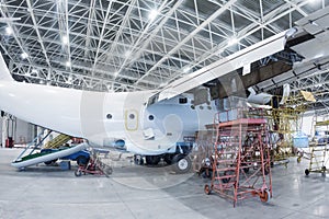 White transport airplane in the hangar. Aircraft under maintenance