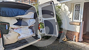 A white transporter van filled with house clearance mattresses and bedding